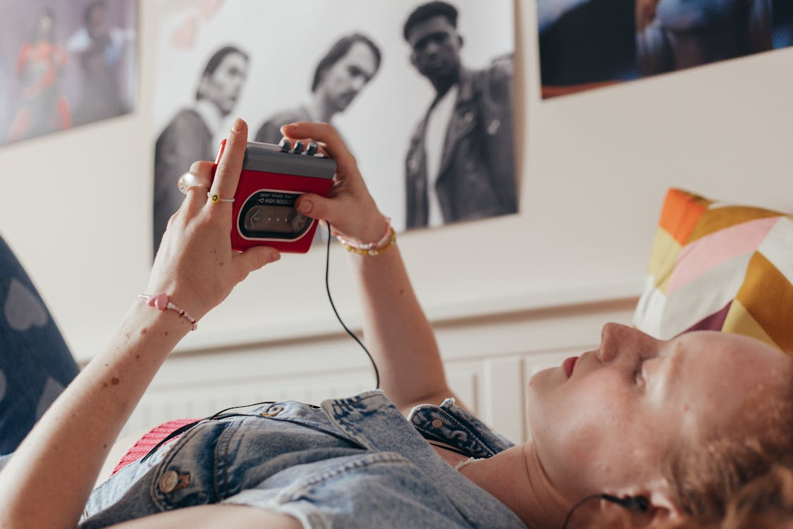 Young woman with a portable cassette player, embracing the analog media revival.