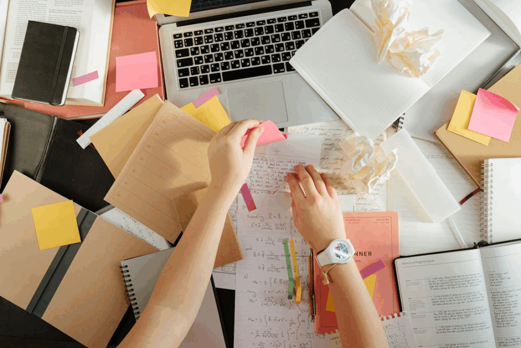 Overhead view of a messy workspace with laptop and crumpled papers, showing how clutter drains focus and energy.