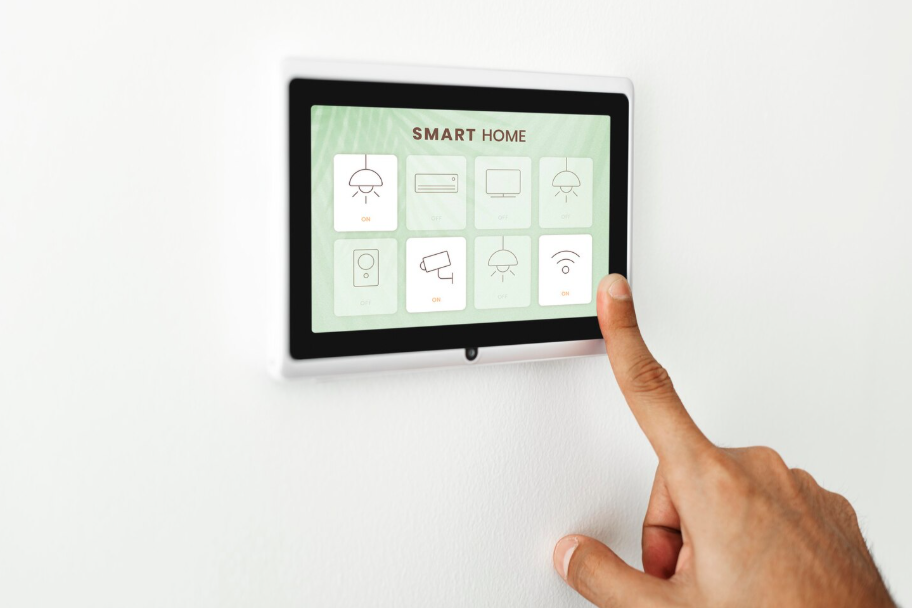 Hand adjusting a smart home panel to automate heating and lighting.