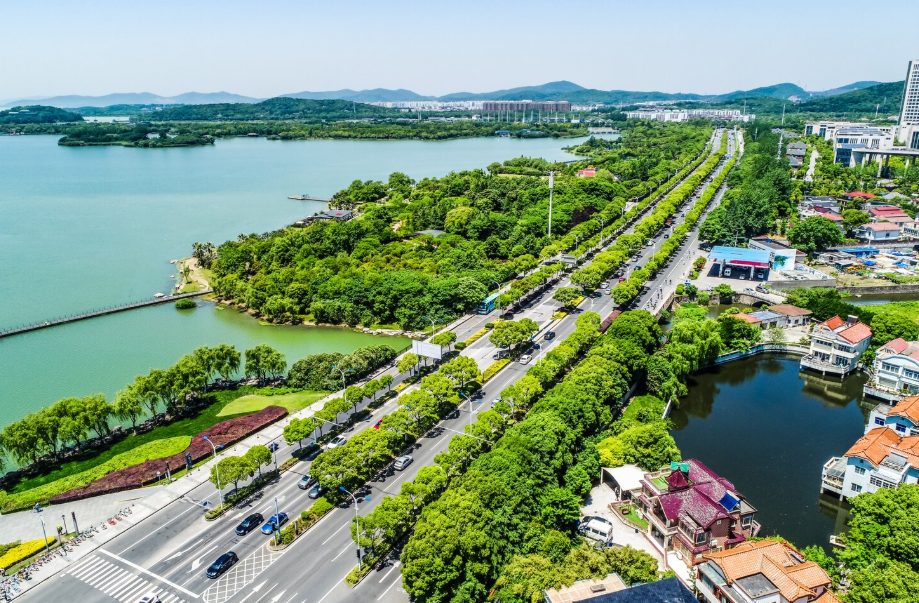 Aerial view of a lakeside city with tree-lined boulevards and waterway parks, showcasing livable city design.
